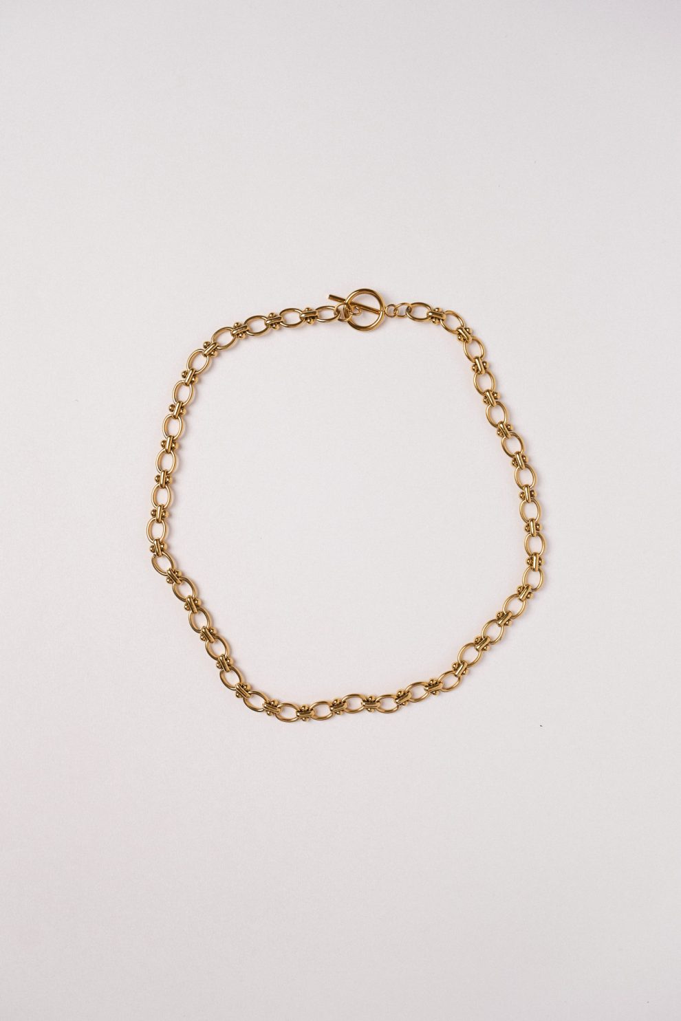 Цепь из овала со вставками из кругляшков в позолоте